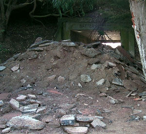 BEGINNING OF IMAGE DESCRIPTION:  THIS IMAGE IS A PHOTOGRAPH OF A HUGE PILE OF BROKEN-UP ASPHALT COMPLETELY BLOCKING THE ENTRANCE TO THE BATTERY DAVIS TUNNEL.  